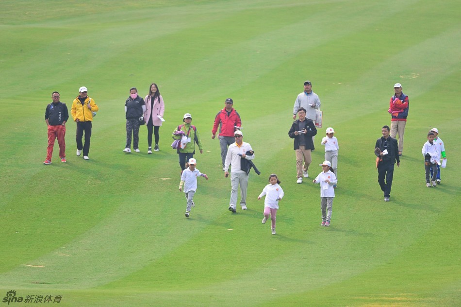 小粉丝聚精会神地看着教练示范击球动作，脸上写满了钦佩与渴望学习的神情