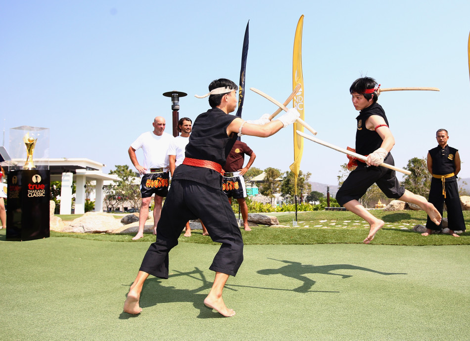 一位球员在沙坑中成功救球，沙砾飞溅的瞬间展现高超的短杆技巧