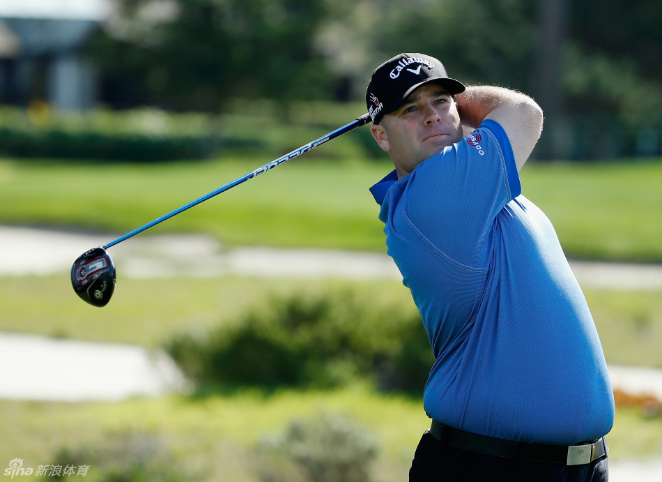 职业高尔夫球手帕特里克·瑞德正在果岭上沉稳推杆，表情冷静专注