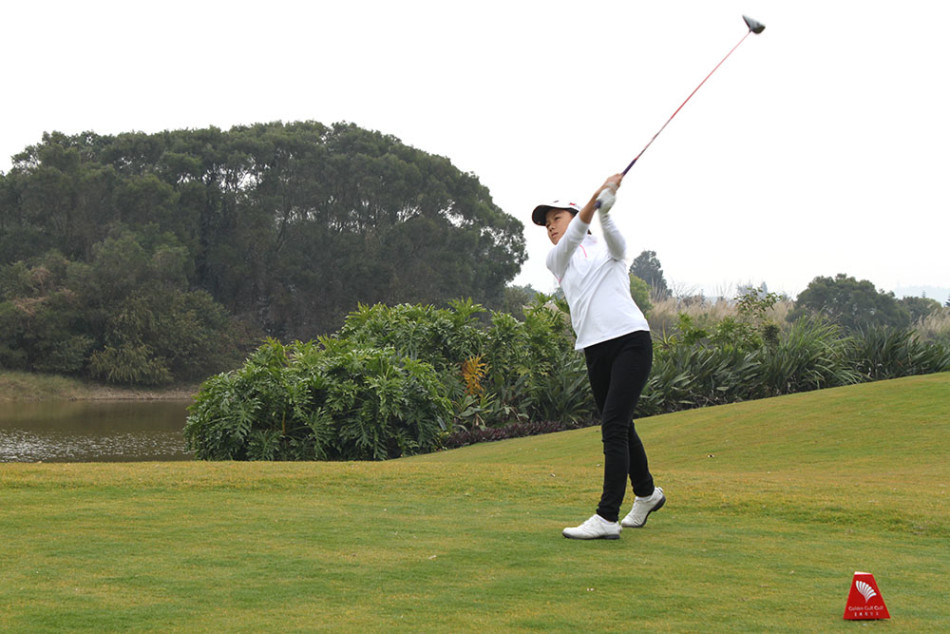 年仅四岁半的参赛者陈锦柳玥在果岭上好奇地观察高尔夫球，小小的身影与广阔的球场形成有趣对比，萌态十足