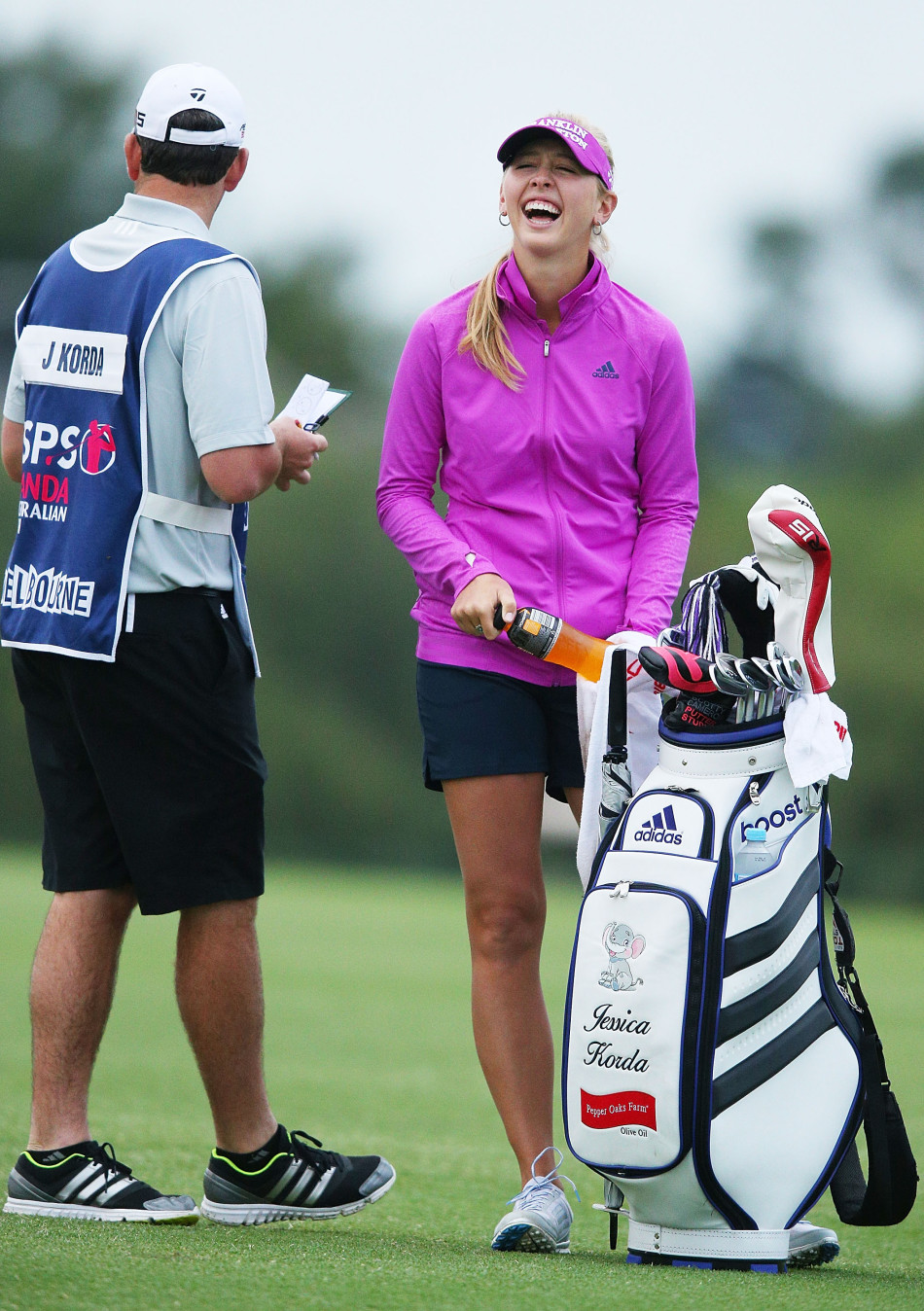 吴秀贤与球童密切沟通,球童正指向远方帮助分析击球策略,展现了赛场上的黄金搭档情谊