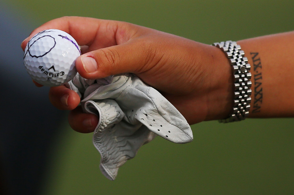 珍妮-申全神贯注地完成攻果岭一击，球杆划出优美的弧线。