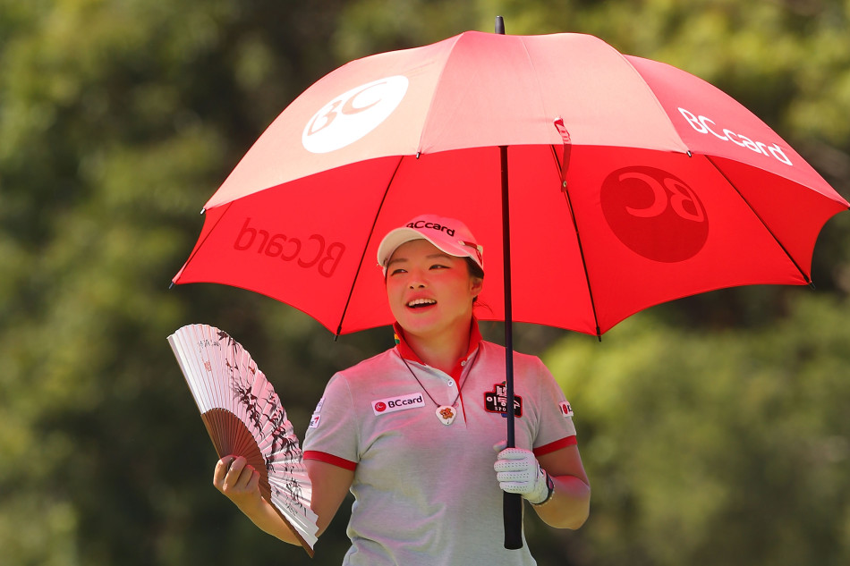 凯莉在果岭边轻柔地拾起她的高尔夫球，耳畔精致的耳环随之微微闪动。