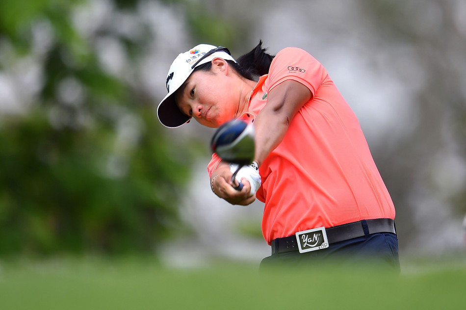 魏圣美大步流星行走在果岭之上，尽管面临挑战，但眼神中依然透露出对胜利的渴望