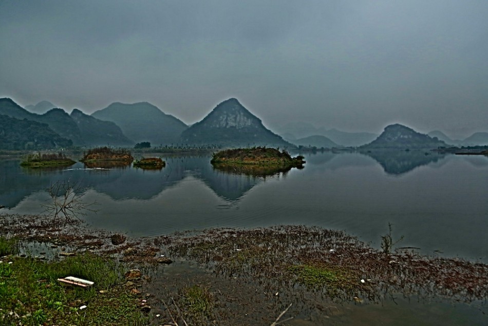 一号洞全景视野，球道如绿龙穿梭于山谷，远处发球台上的身影成为山水画中的点睛之笔