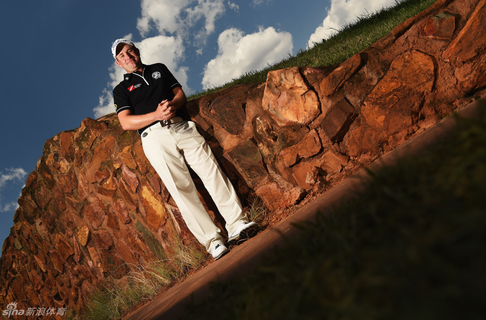 安迪-苏利文面带微笑与友人轻松交谈，背后的悬崖与阳光勾勒出温馨的赛间休闲场景。