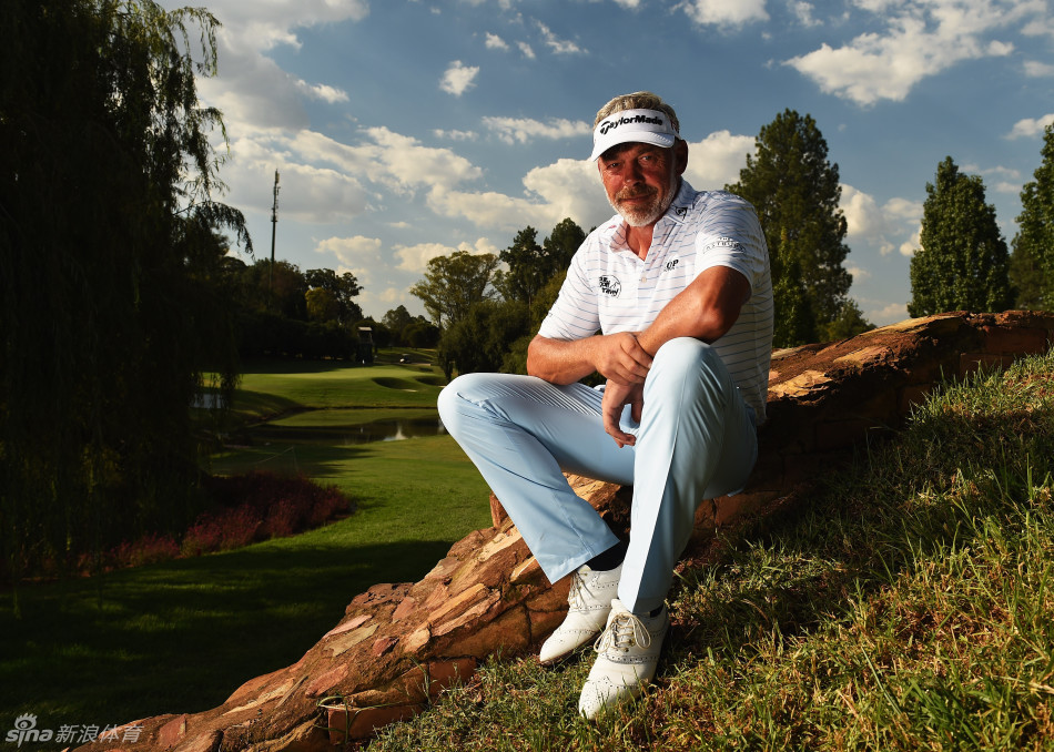 保罗-曼迪背靠岩壁悠然小憩，手中的饮料和放松的姿态尽显大赛间隙的惬意时光。