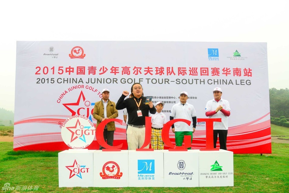 身着统一队服的青少年高尔夫队伍手持红旗精神抖擞地列队入场，士气高昂