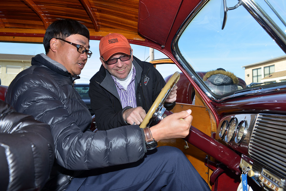 一组别克车主们站在几台熠熠生辉的经典车前合影,他们姿态轻松,脸上洋溢着因共同爱好而相聚的纯粹快乐。