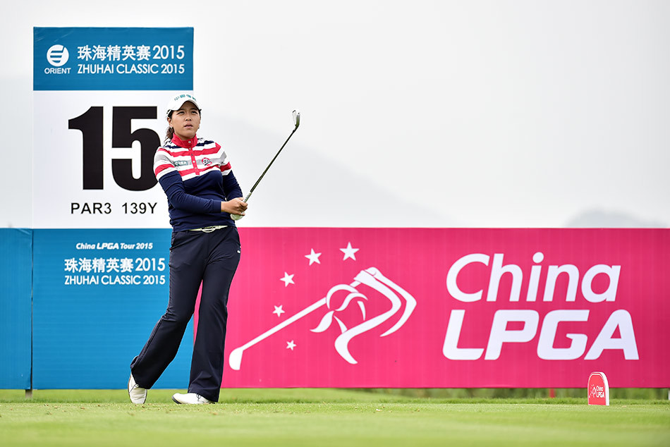 中华台北美女球手叶欣宁正与球童低声交流，专注商讨下一杆的策略，体现了完美的团队协作。