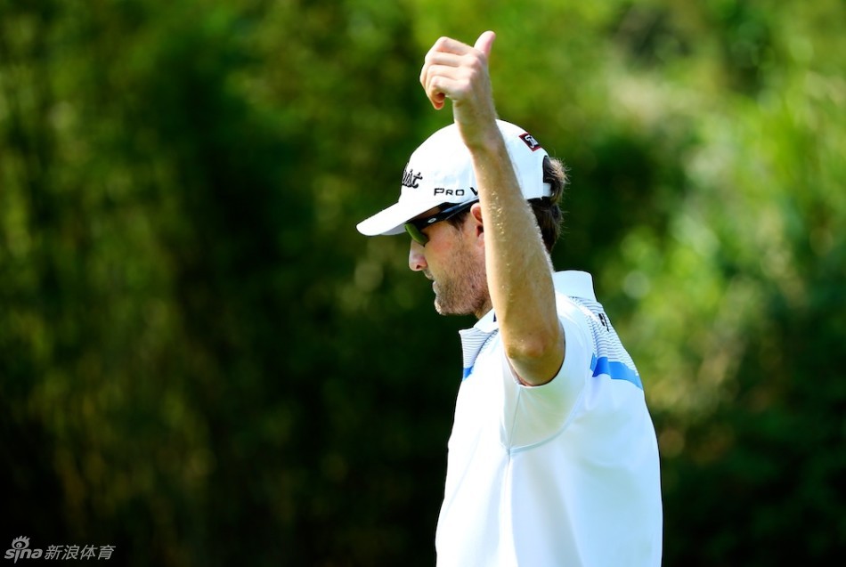 飘扬的旗帜：别克高尔夫挑战赛的赛旗在湛蓝天空下迎风飘扬，背景是郁郁葱葱的球场