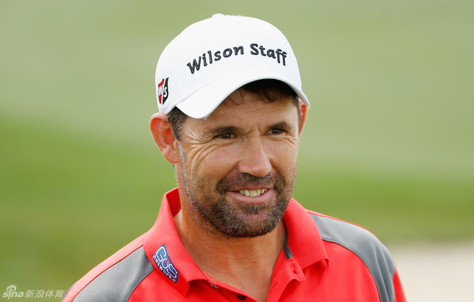 南非选手舒瓦泽尔在果岭边沉稳观察线路，身旁的赛事旗帜在风中微扬