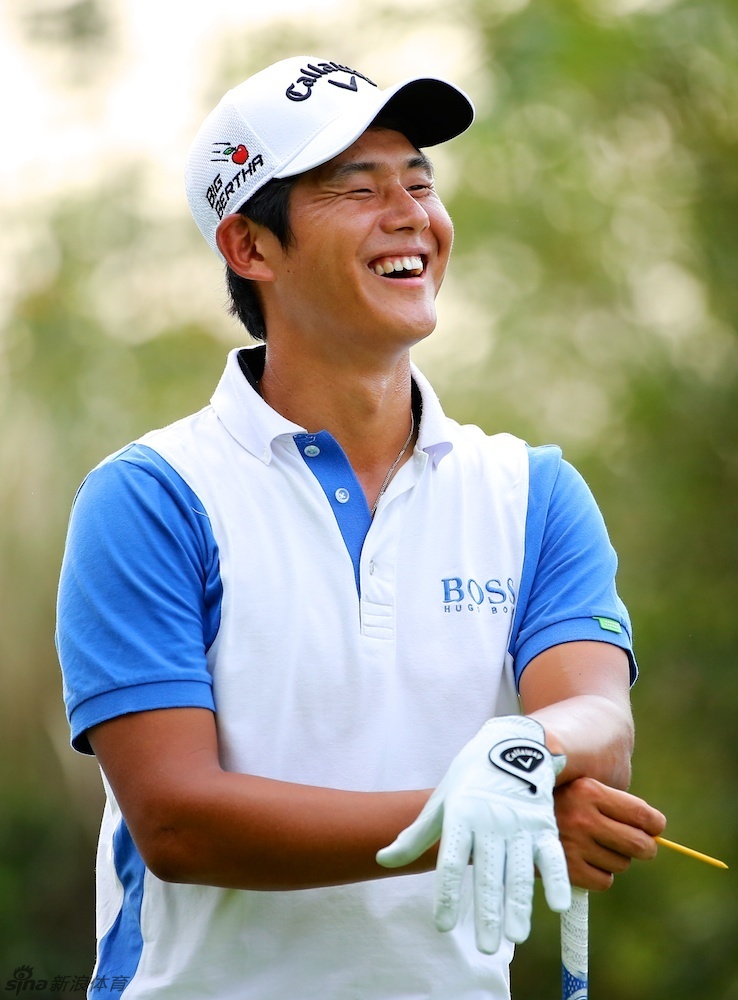 中国小将陈子豪在果岭边专注观察推杆路线，神情坚毅，展现了年轻球员的认真与执着。