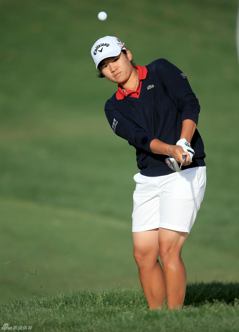 曾雅妮在果岭边沙坑中优雅挥杆，沙粒随球杆扬起，她全神贯注地控制着击球的角度与力度，力求将球送到洞杯旁。