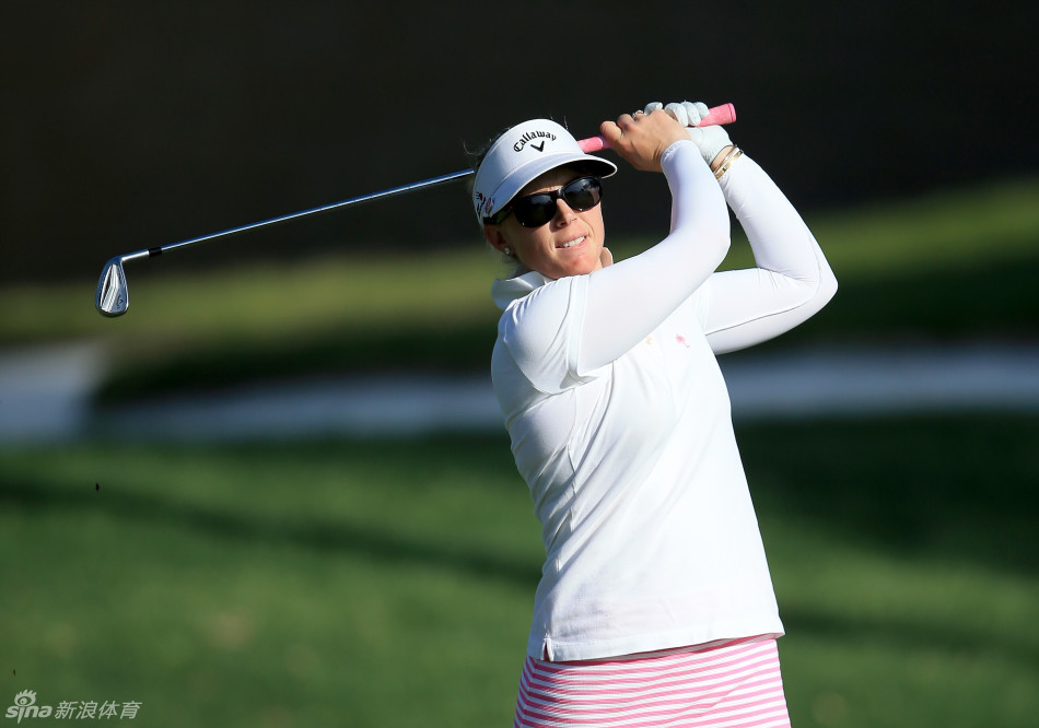 德国选手桑德拉-盖尔身着时尚便装，在都市背景下进行趣味挥杆，她笑容灿烂，为传统高尔夫运动注入新鲜的时尚活力。