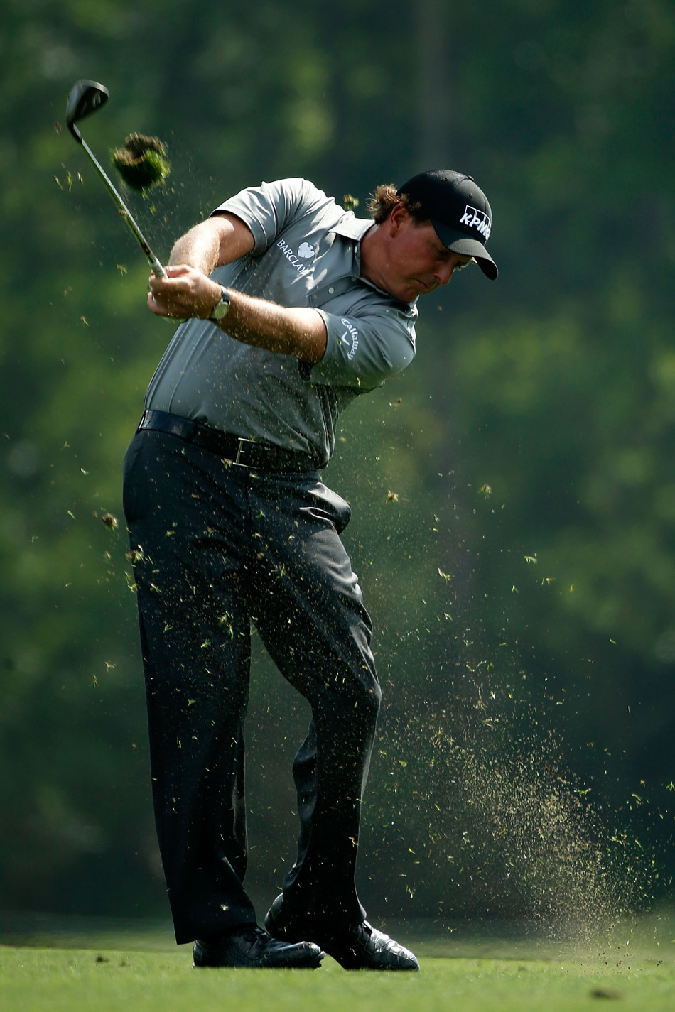 菲尔·米克尔森与资深球童‘骨头’吉姆·马凯在球道边低头密语，认真商讨下一杆的策略与选杆。