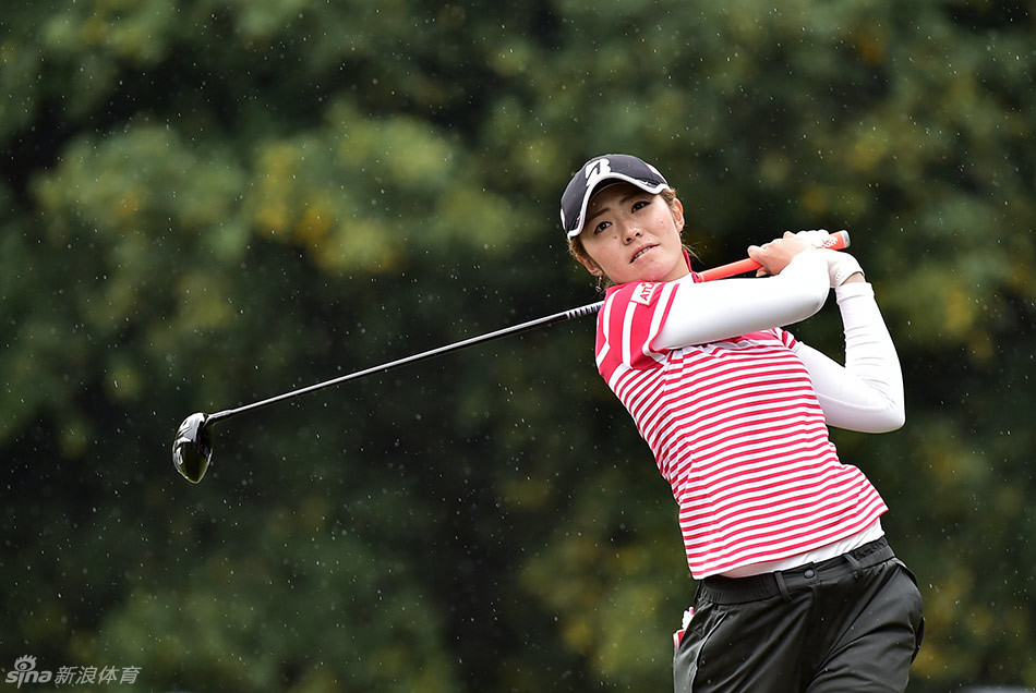 中国选手黎佳韵与她的球童在果岭边并肩而立，认真讨论战术，体现了团队合作的重要性。