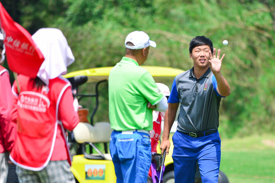 一颗色彩鲜艳的高尔夫彩球被球杆击中瞬间,在空中静止,背景是湛蓝的天空与开阔的球场