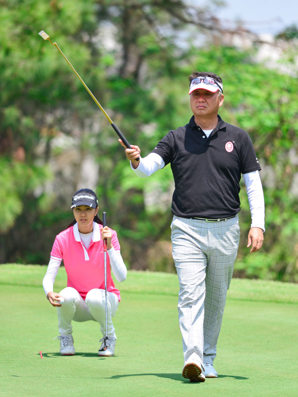 陈忠和教练面带熟悉的微笑,在高尔夫球场发球台上优雅转身完成挥杆,身后是欣赏的观众