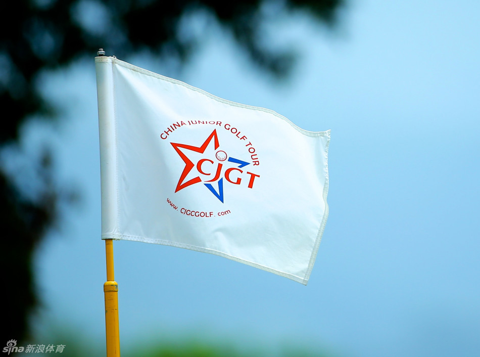 两位小球员在果岭边并肩而立，专注地低头研究推击线路，阳光洒在他们身上，映照出专注与求知的光芒。