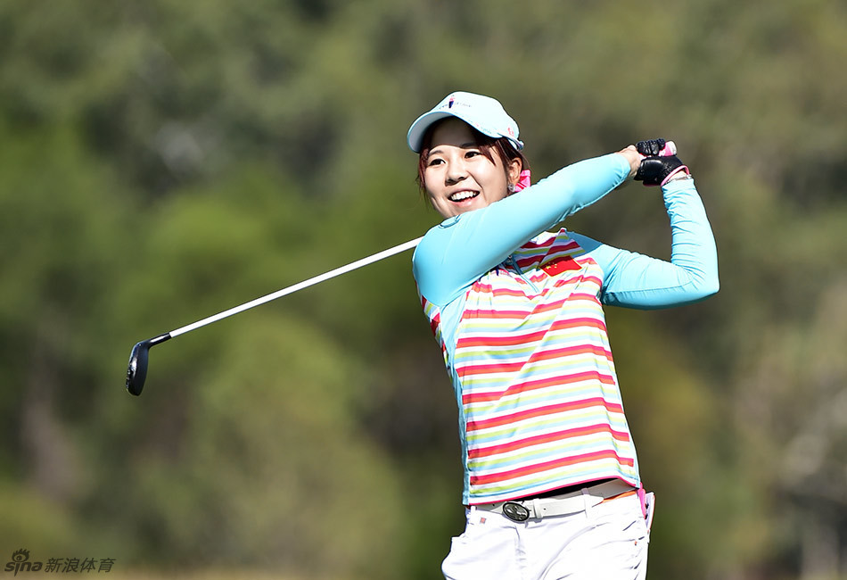 张玉阳在果岭旁绽放灿烂笑容，展现了高尔夫运动带来的纯粹快乐