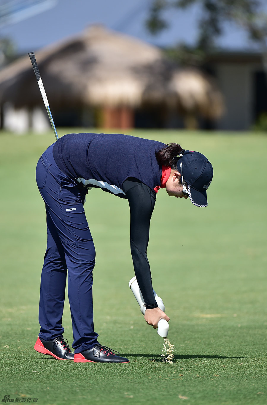 选手在沙坑中进行细致的击球准备，专注的神情与专业的动作尽显职业素养