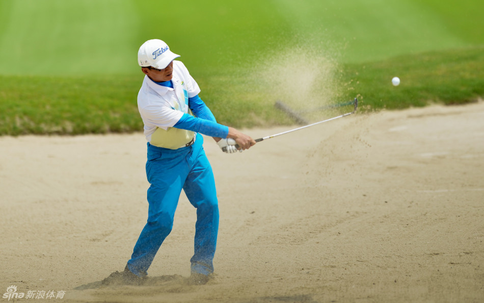 选手在金湾球场如诗如画的球道上全神贯注地准备挥杆,身影与远山绿草融为一体,展现高尔夫运动的宁静与力量之美。