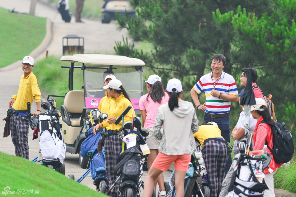 广州队宋烨荧全神贯注准备推杆，场边家长与领队凝神观赛