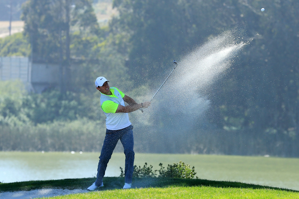 查尔·舒瓦泽尔在果岭旁沉稳等待,阳光洒肩头,眼神中充满对胜利的思索与渴望。