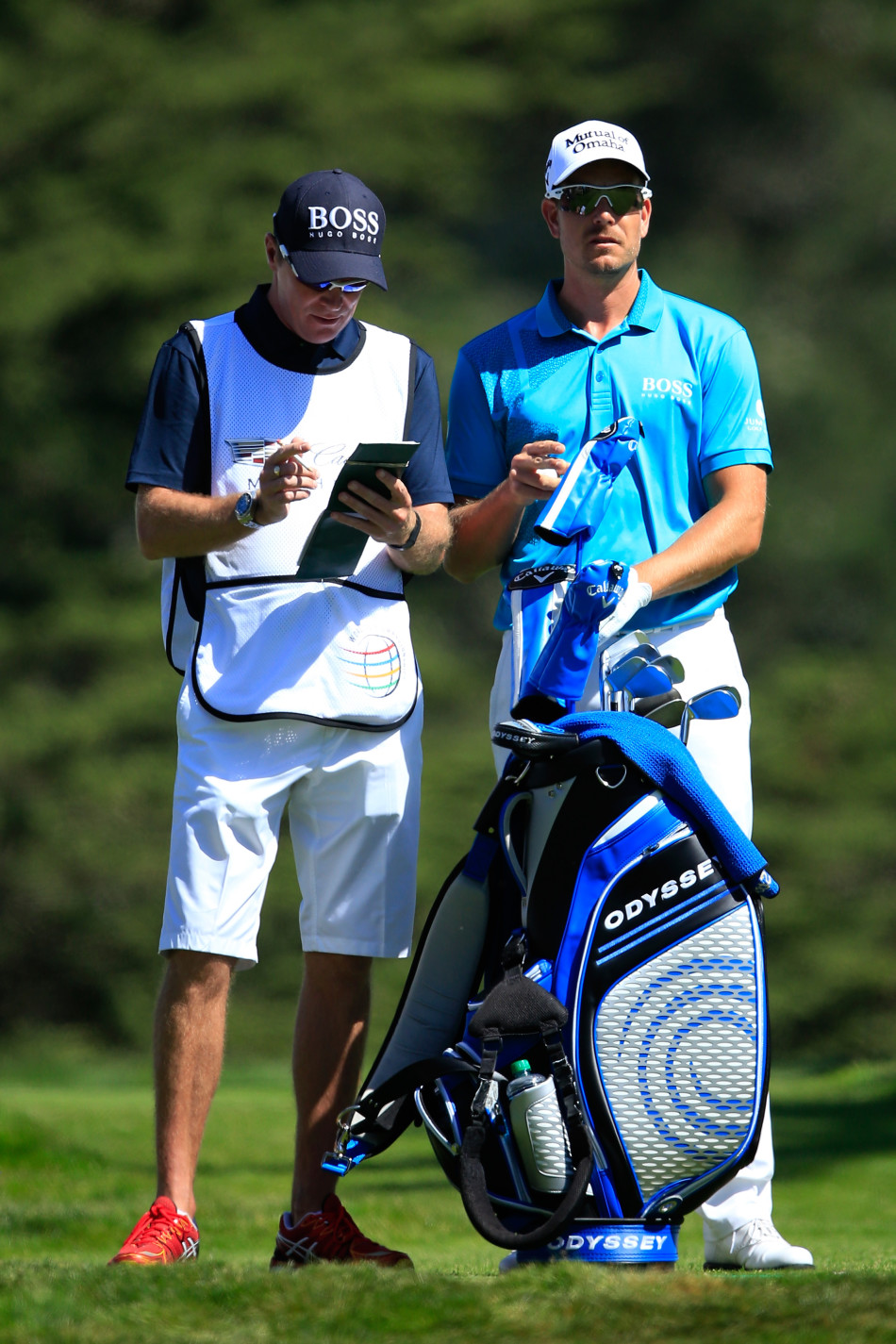 罗里·麦克罗伊半蹲于果岭边,目光如炬,正细致入微地解读着果岭复杂的起伏与草纹。