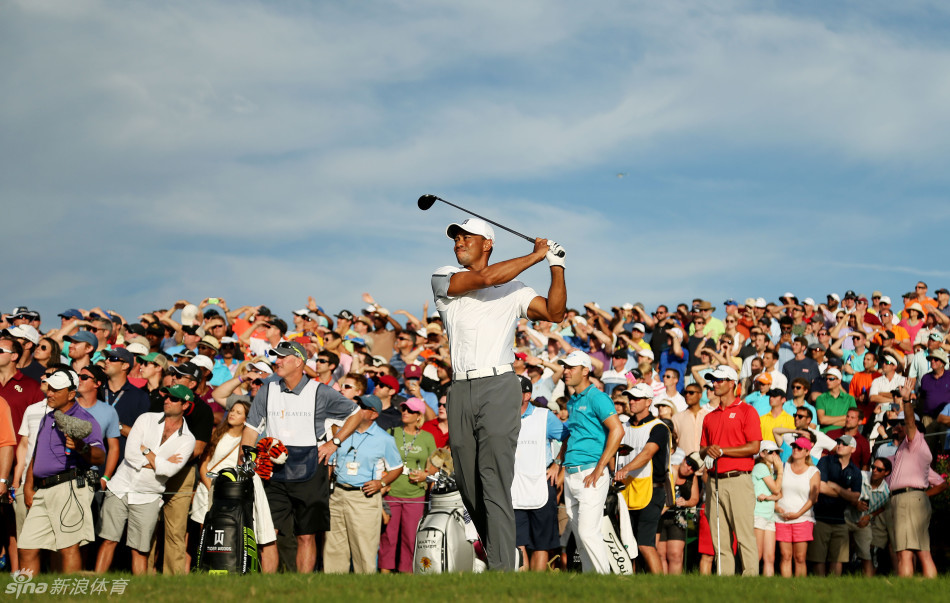 泰格·伍兹在奥古斯塔练习轮中全神贯注地开球，身后庞大的观众人群见证着王者归来的吸引力。