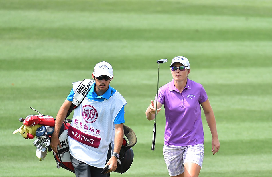 冯珊珊在果岭上俯身,专注审视小球滚动路线与洞杯位置