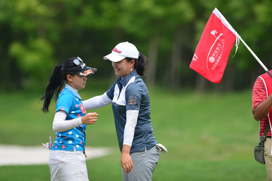 巾帼英姿：莫宝华与陈敏柔在决赛中同组竞技，两人正专注地审视果岭线路。莫宝华表情坚毅，陈敏柔凝神思考，阳光将她们的身影拉长，一场关于技巧与心态的无声较量正在青翠的果岭上静静上演。