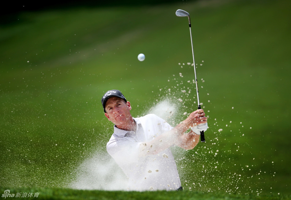 米克尔森在沙坑中奋力一击救球,身体姿态显示出对困难球位的完美控制,沙坑杆划出一道弧线。