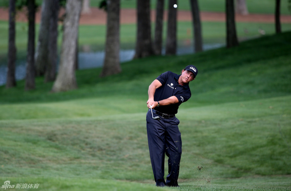 福瑞克正从沙坑中成功救球,沙砾飞溅,小球带着漂亮的倒旋飞向果岭旗杆。