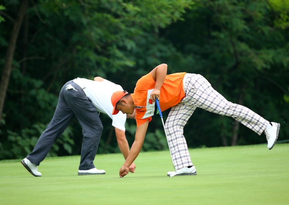 曹一在攻果岭后露出满意微笑,背景中球童正竖起拇指,小球静静躺在果岭上,距离球洞仅一步之遥