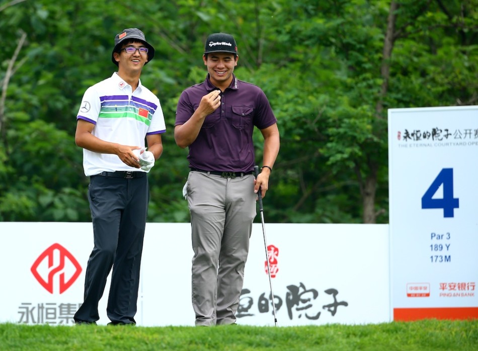 张新军在全场注视下优雅挥杆,小球应声飞向果岭,背景是观众充满期待的目光与连绵的球场绿丘