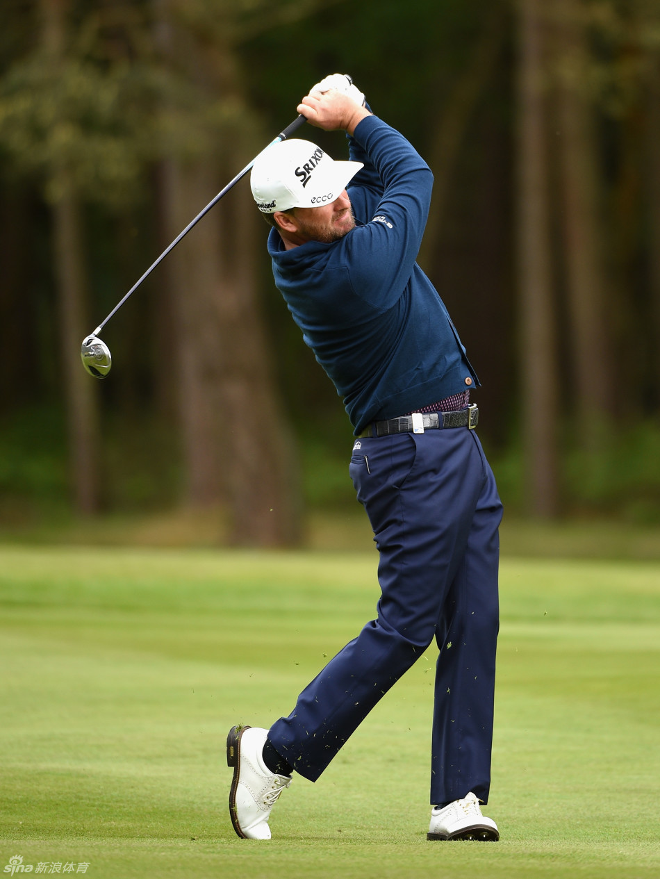 罗斯与球童在赛场上并肩站立认真观察球道共同商讨下一杆进攻策略