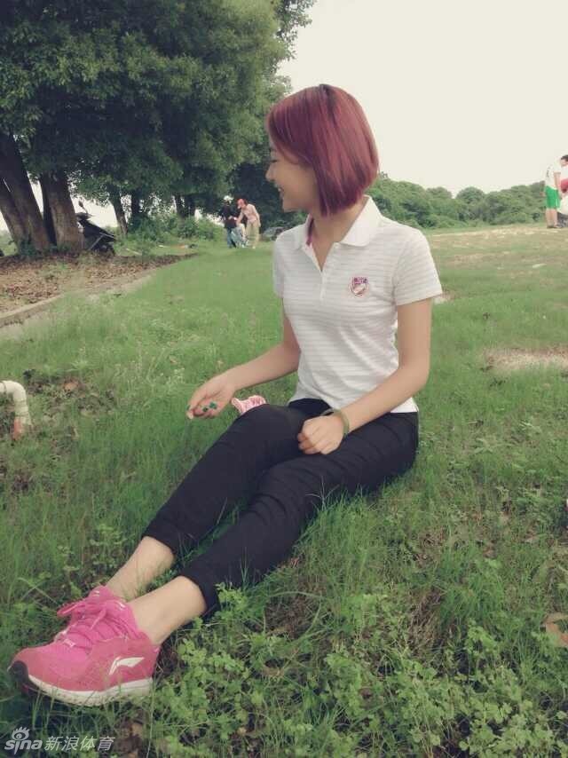 选手身着专业高尔夫运动装，在果岭旁优雅屈膝，进行推杆前的细致观察