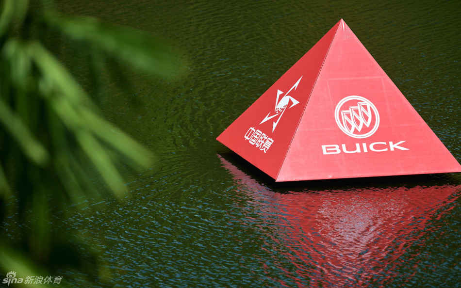 球员凝神静气于湖边果岭，推杆瞬间，水面倒影如画