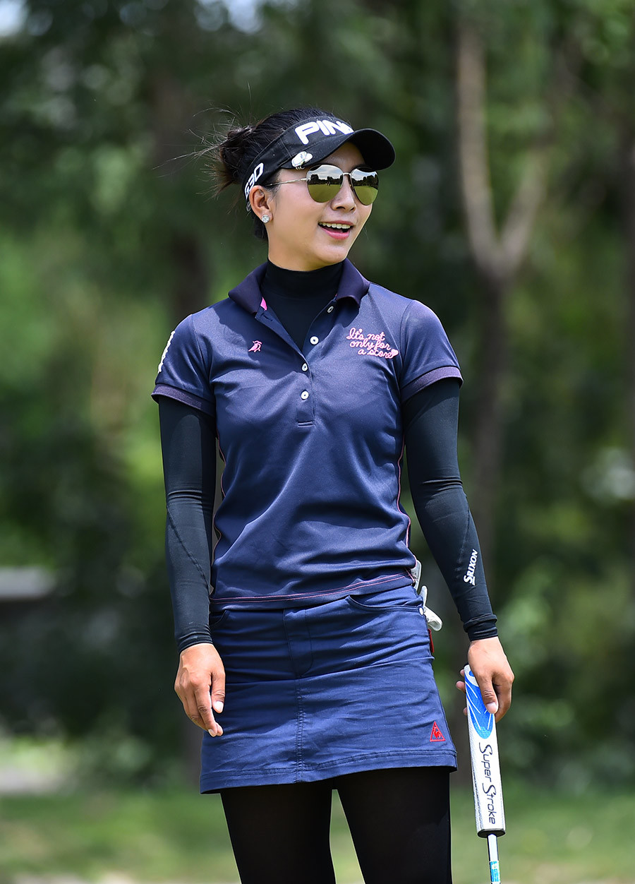 选手潘艳红在微雨中撑伞前行，步伐坚定地与同伴走向下一个挑战。