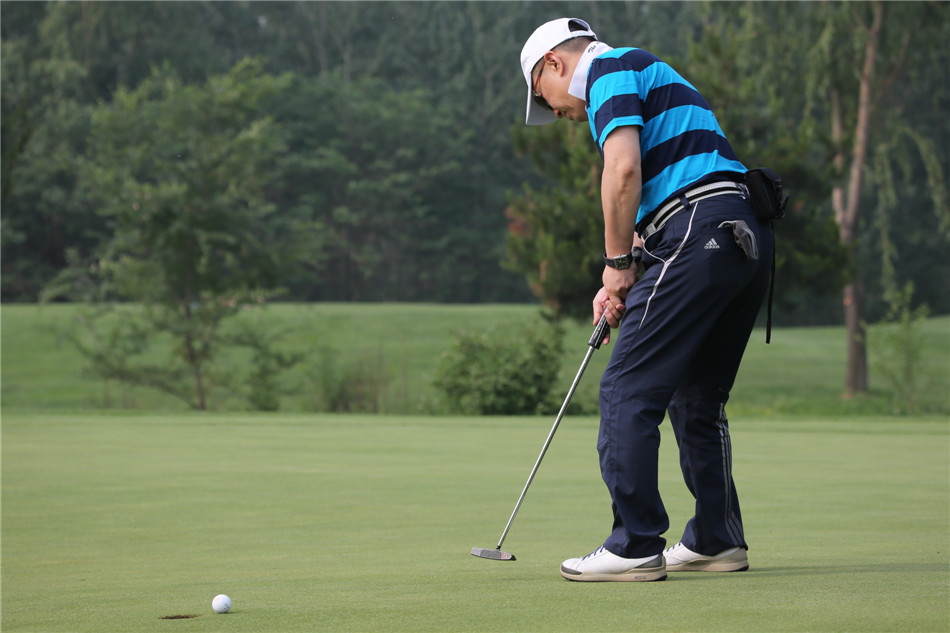 著名演员陈晓东在果岭边全神贯注,轻柔推杆,白色小球朝着球洞缓缓滚去。