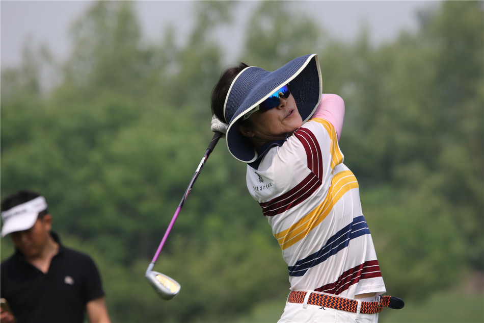 队员郭虹正蹲在果岭边,聚精会神地观察小球与球洞之间的草坪线路,研判最佳的推杆路径。