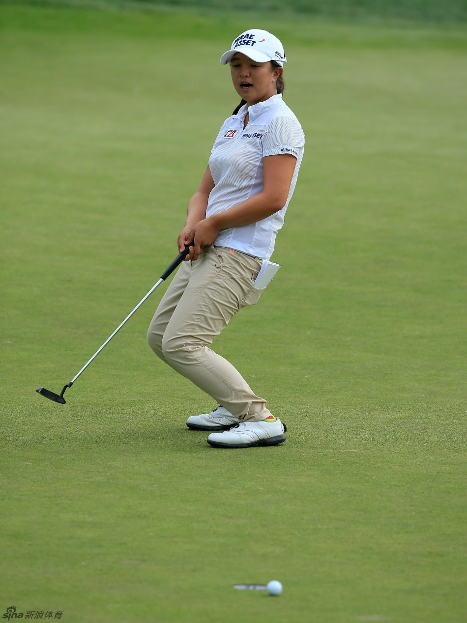 玛丽娜·亚力克斯在长草区中救球,她正专注地观察球位,准备进行一次关键的技术性击球。