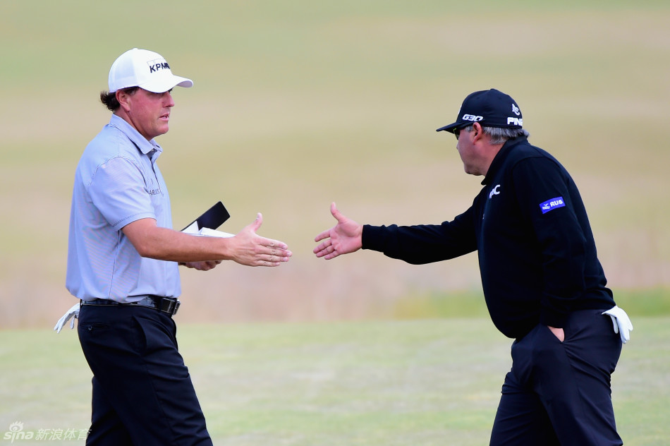 果岭上米克尔森单膝跪地,全神贯注地研读推杆线路