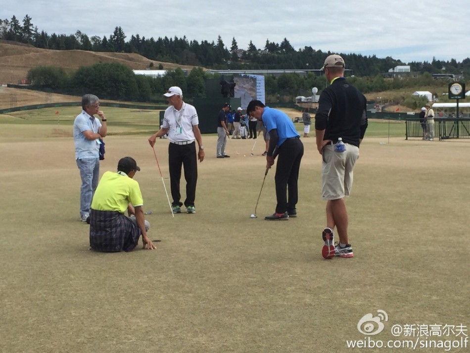 梁文冲在练习果岭上全神贯注地练习推杆，目光锁定前方球洞