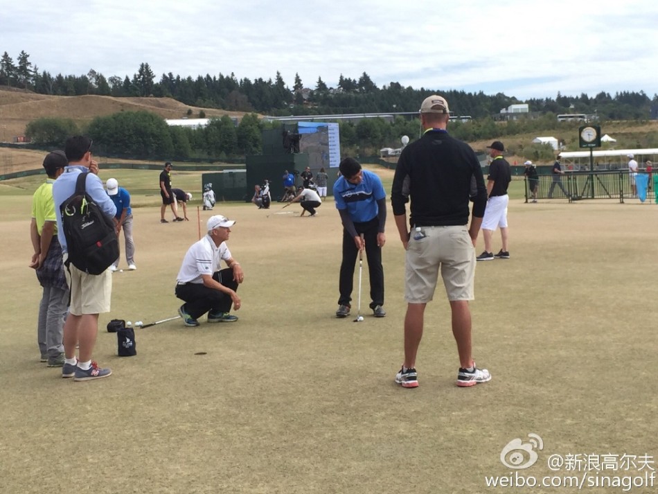 梁文冲俯身仔细观察果岭草纹与坡度，为推杆线路做最后测算