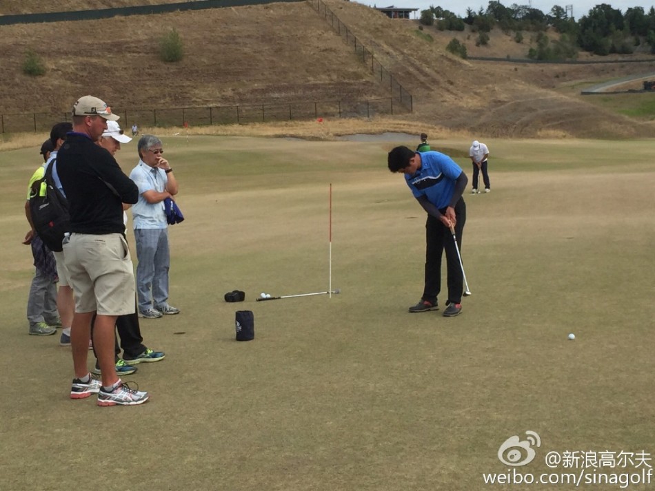 梁文冲与教练交流推杆技术，共同分析并寻求改进之道