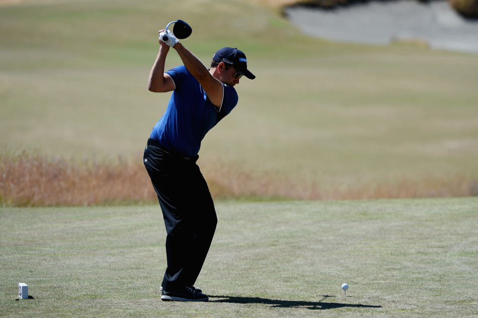 美国选手埃里克-康普顿在球员锦标赛上全神贯注地准备推杆，眼神坚定，果岭线清晰可见。