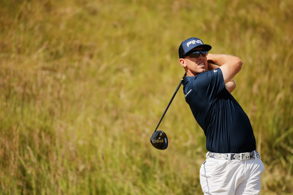 亨特-马汉赢得冠军后，满怀喜悦与自豪地双手高举冠军奖杯，笑容灿烂。